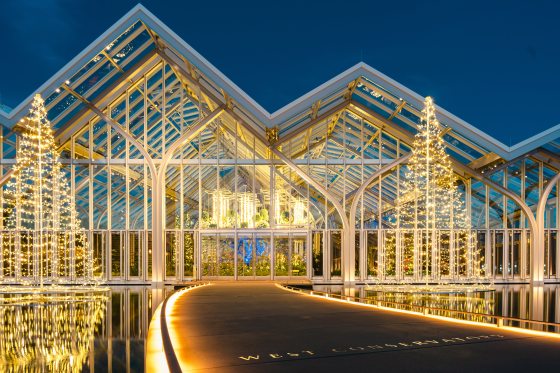 The West Conservatory at Longwood Gardens lit up in white Christmas lights at night.
